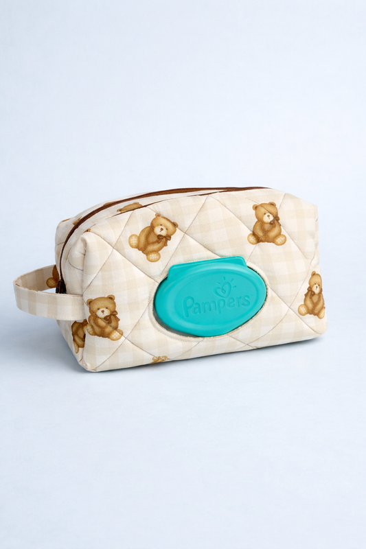 Quilted toiletry bag with teddy bear pattern and turquoise logo on a light gray background